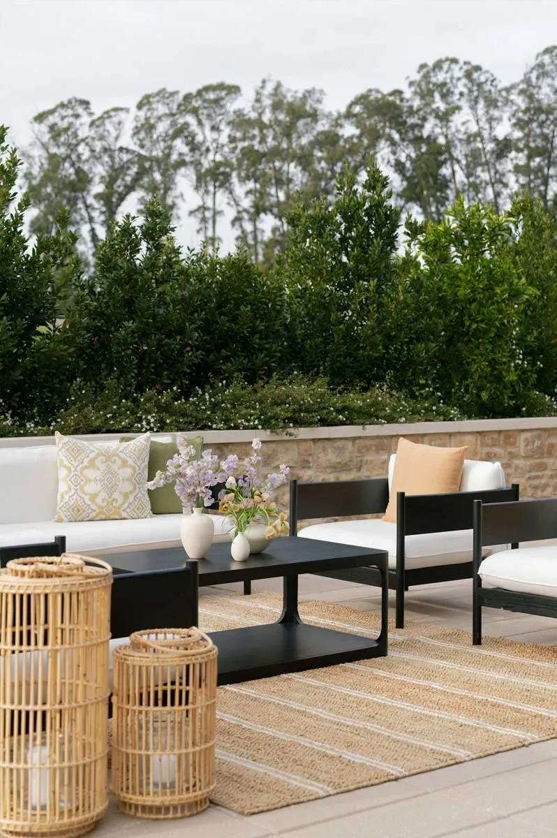 Outdoor lounge setup with rattan side tables and rugs