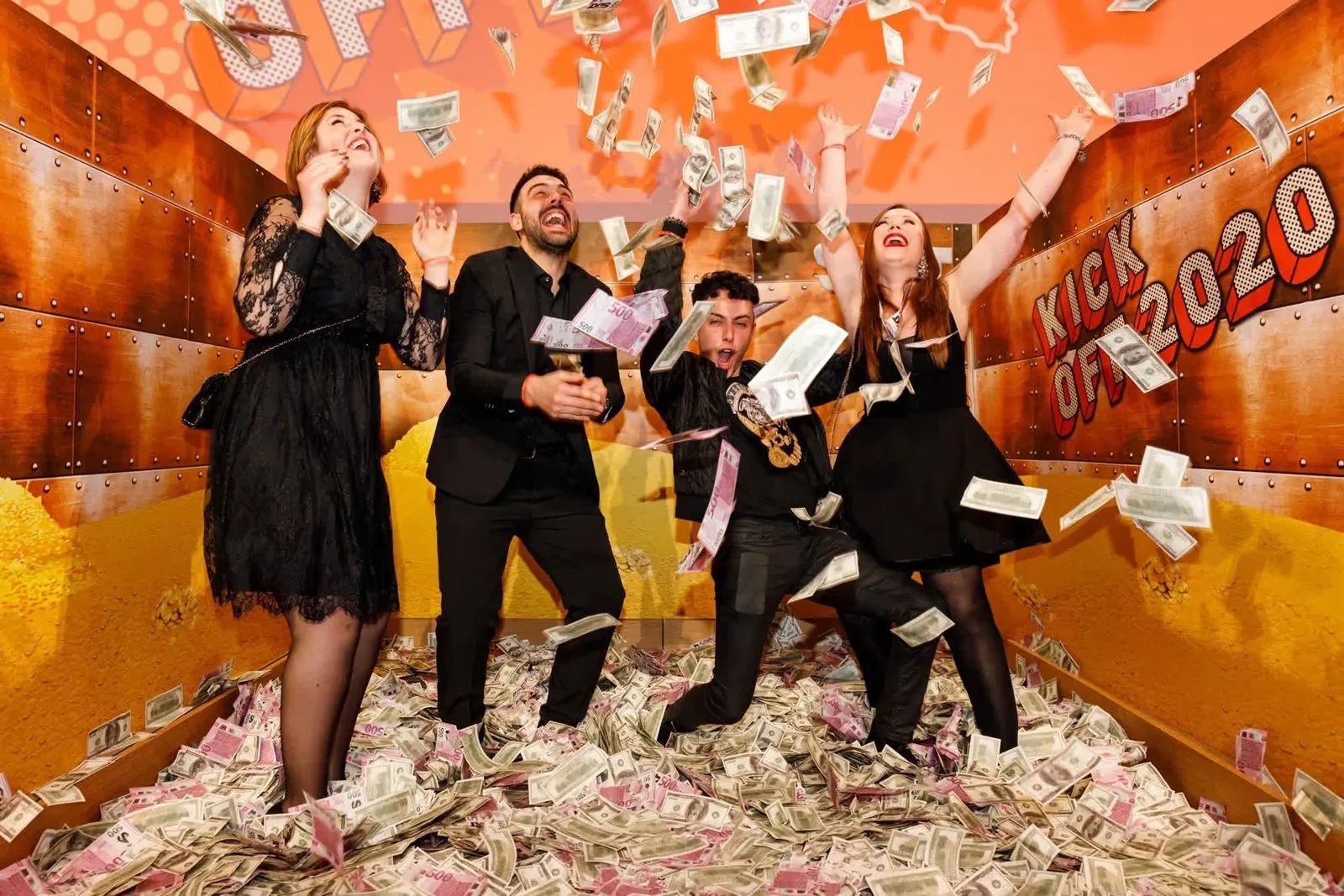 Four people posing under falling paper in a booth with a Kick Off 2020 backdrop