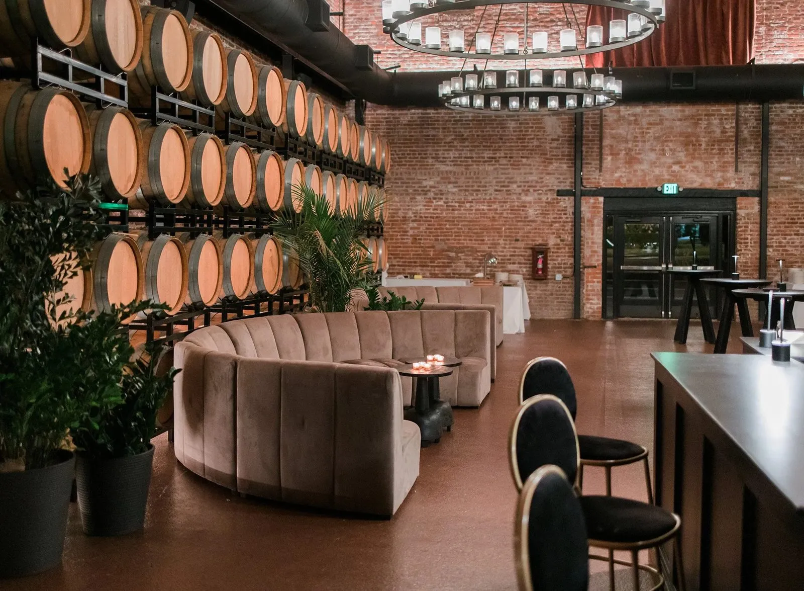 Lounge seating and a bar in a winery barrel room set up for a reception