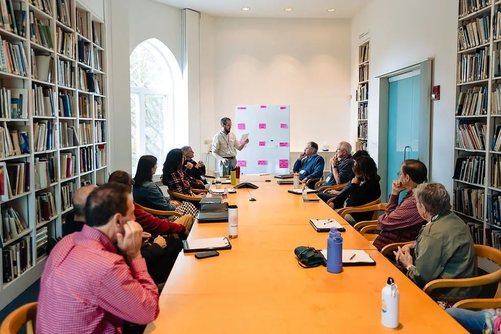 Team workshop around a long table in a library style room