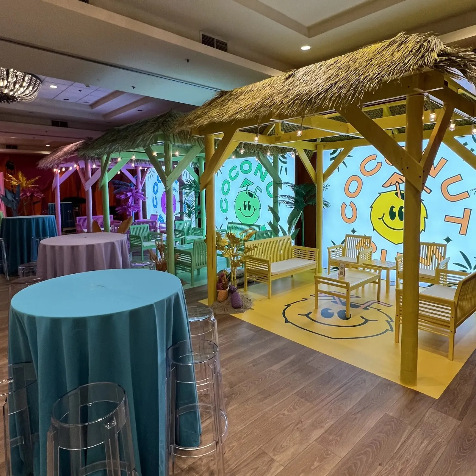 Themed event set with a thatched-roof bar and lounge seating