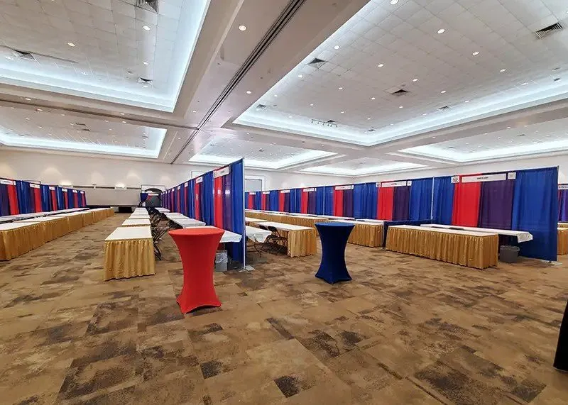 Expo floor with booths and draped tables