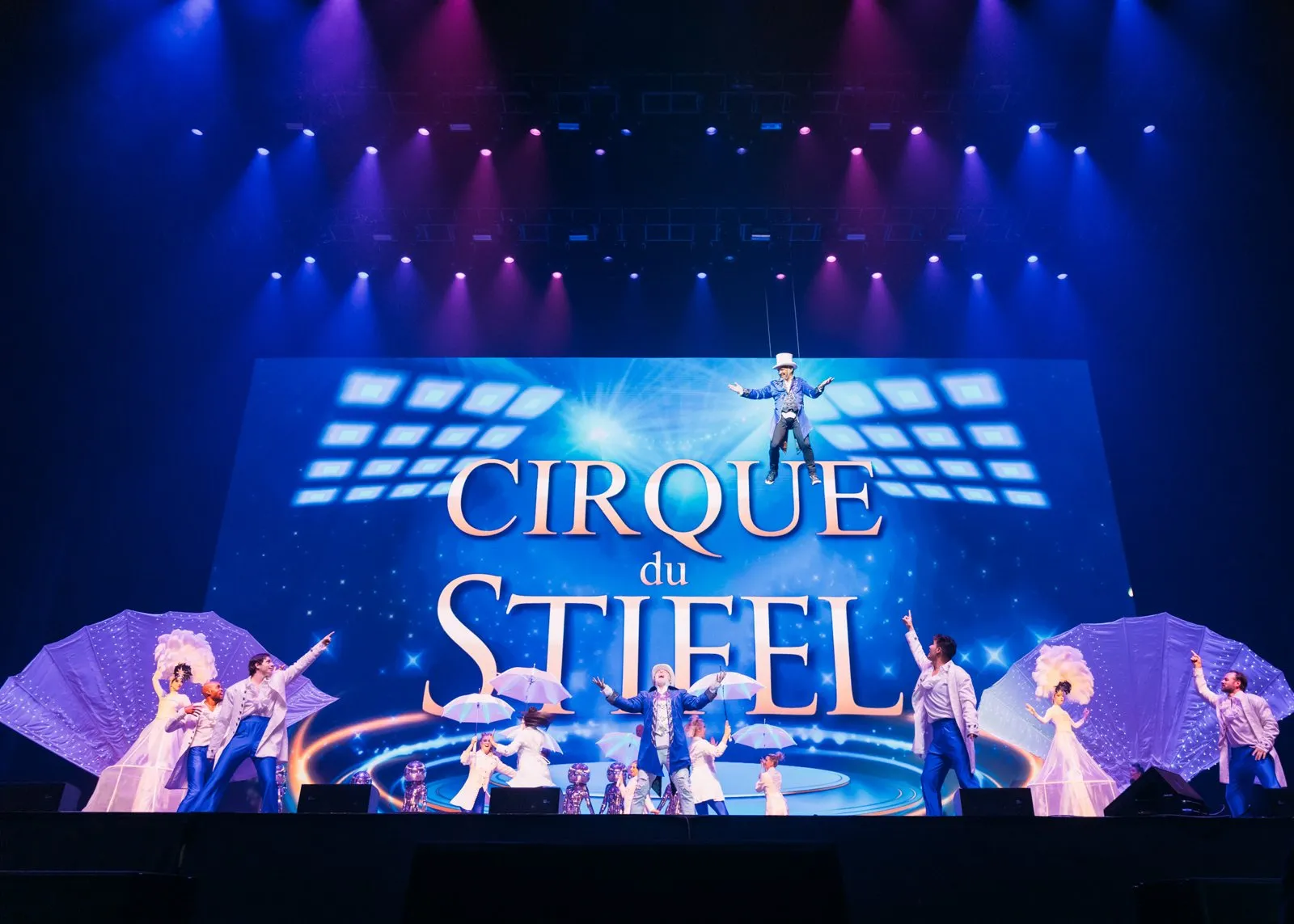 Cirque du Stifel stage with performers and a lit screen