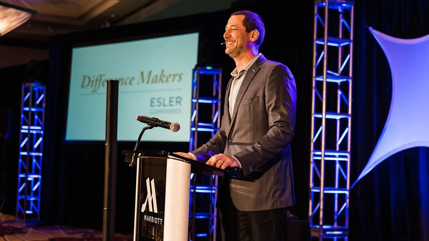 Keynote speaker at a podium beside stage lighting trusses