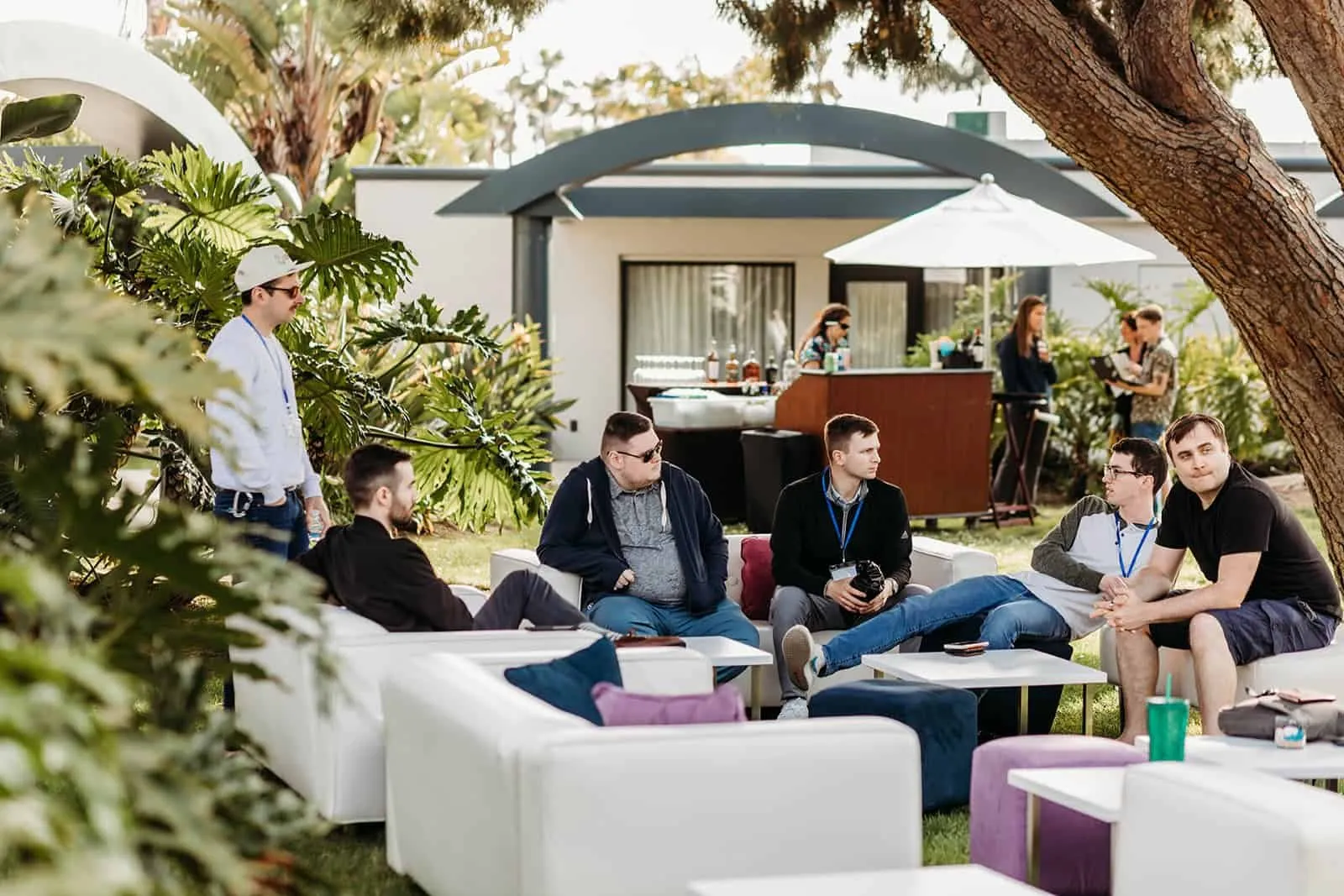 NOYO retreat guests relaxing in a white-cushioned garden lounge at Paradise Point, San Diego
