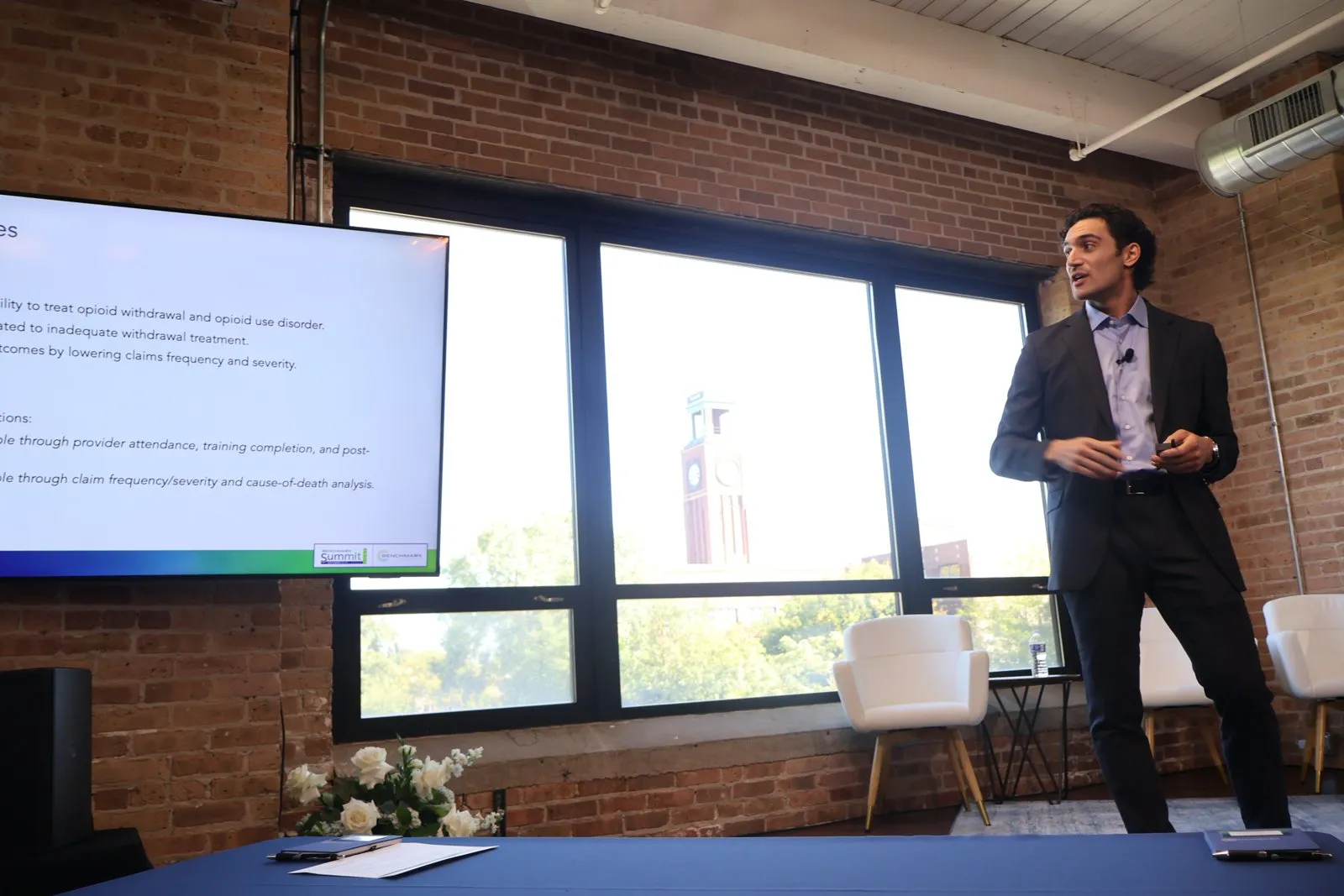 Speaker presenting in a brick-walled loft at the Benchmark summit
