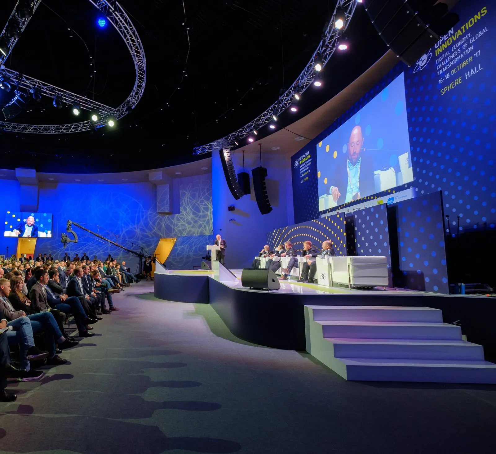 Corporate summit general session with a large screen and stage lighting