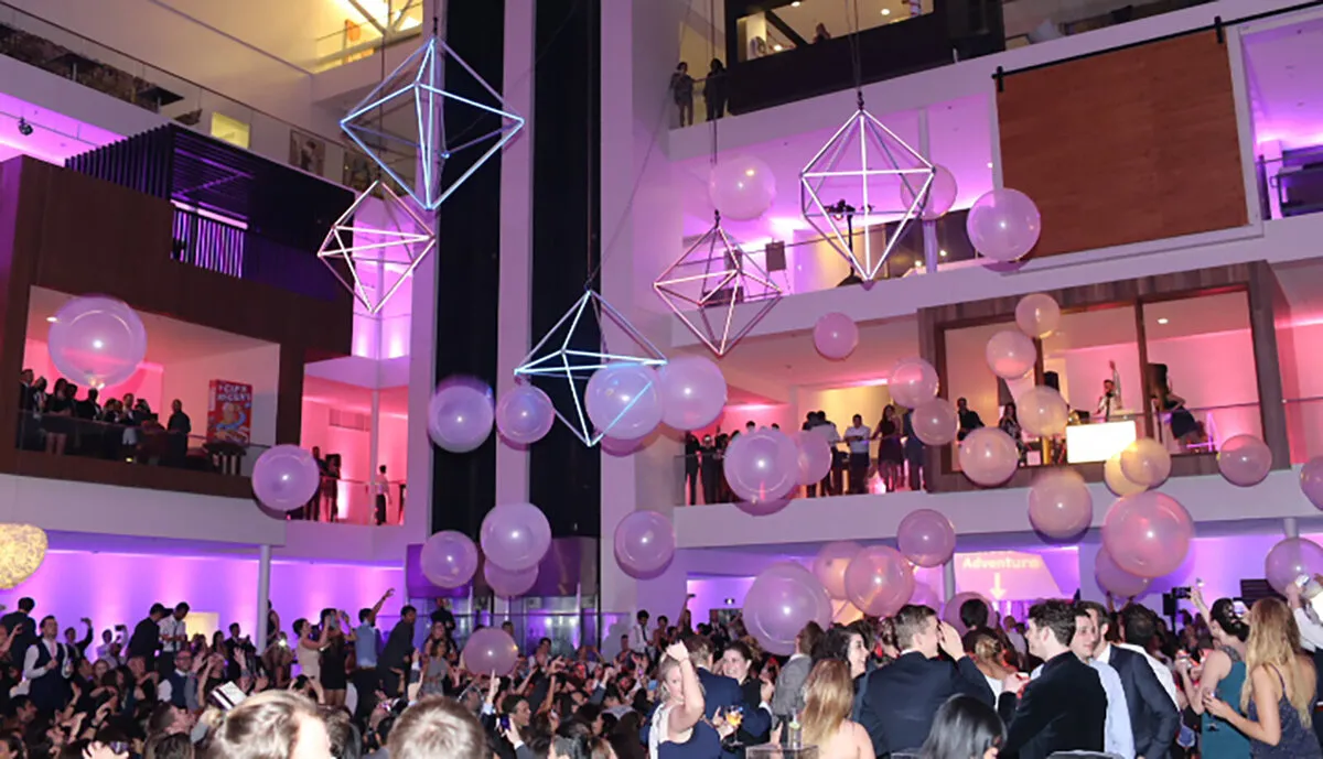 Atrium party with pink lighting and a balloon drop