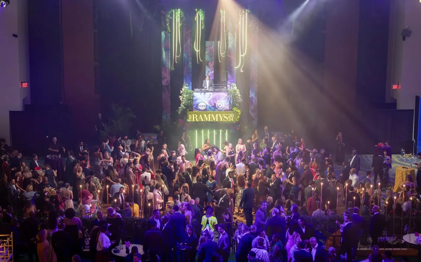 Packed audience under stage lighting at an evening program