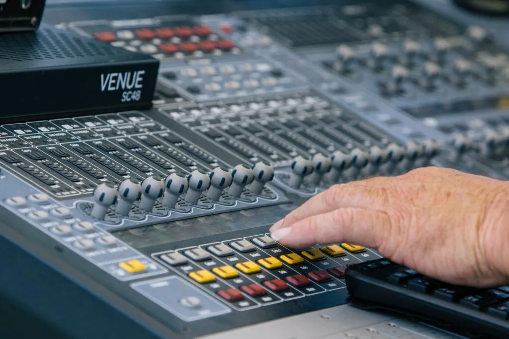Technician operating a digital audio mixing console