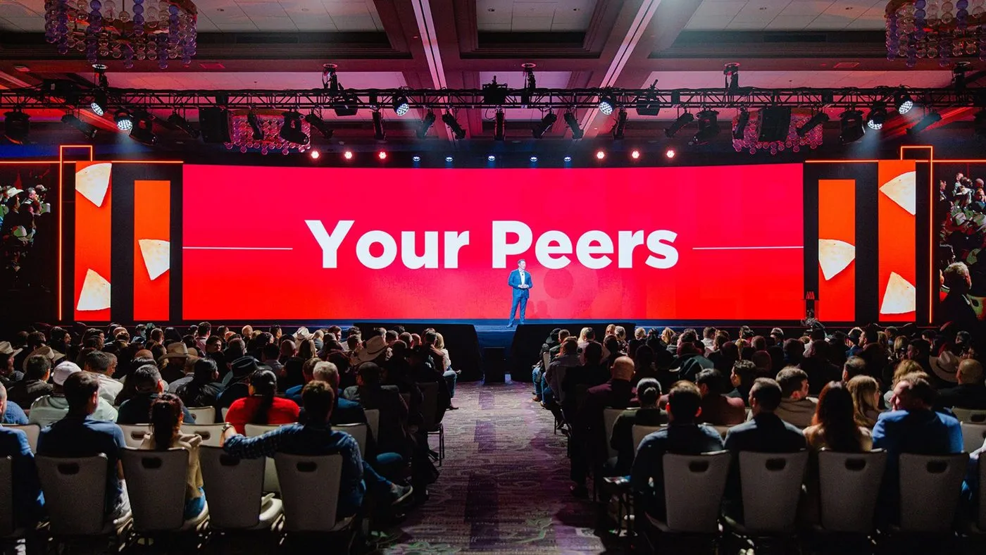 General session with a speaker on stage in front of a seated audience