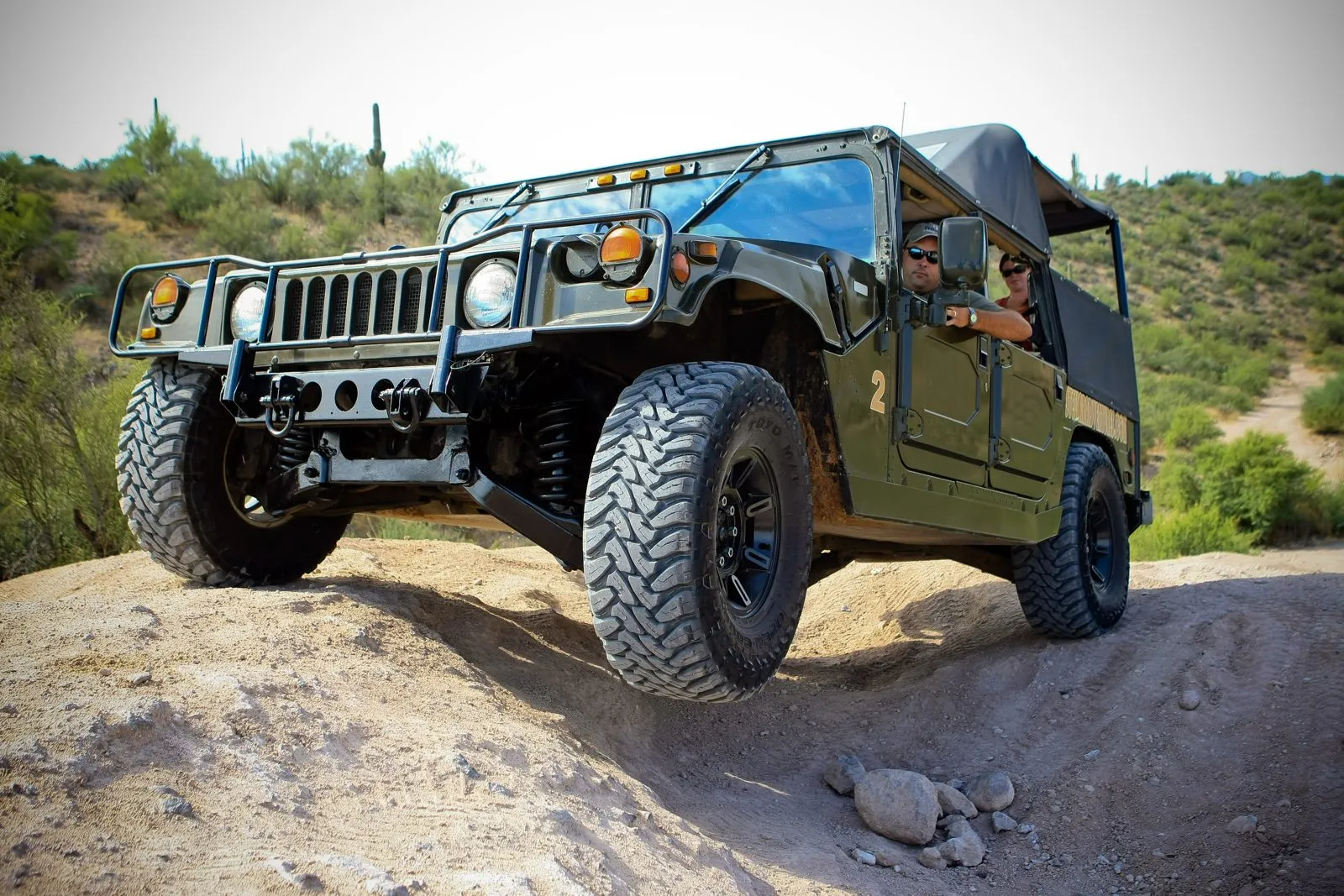 Off-road tour vehicle on a rocky desert trail