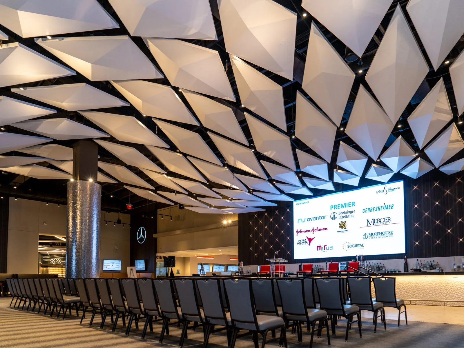 Conference room set with rows of chairs facing a presentation screen
