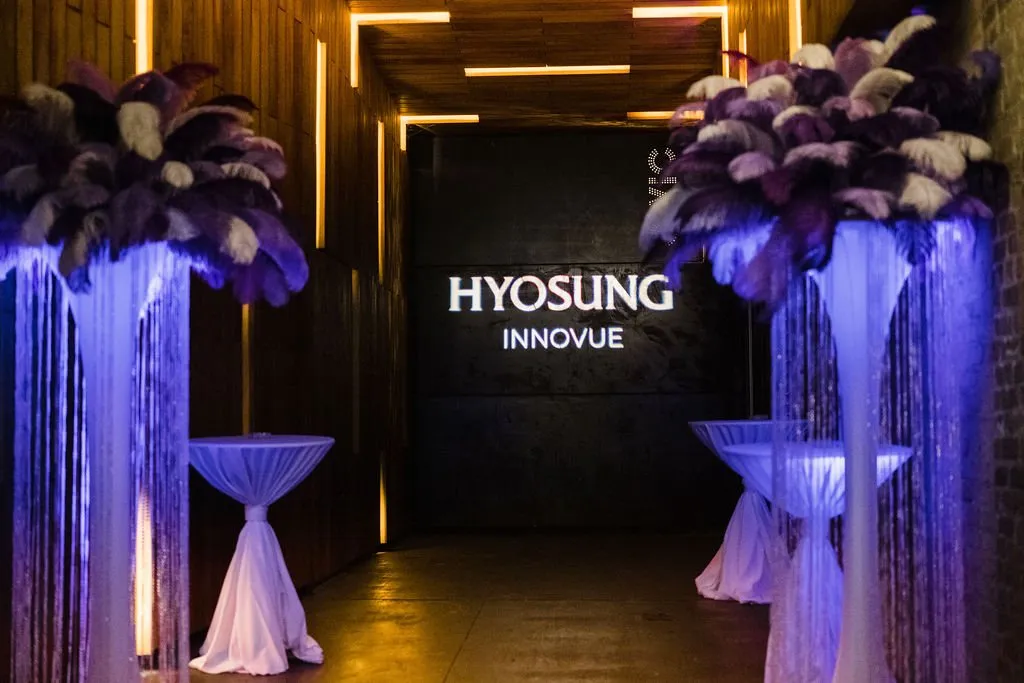 Hyosung Innovue brand launch entrance framed by feathered centerpieces