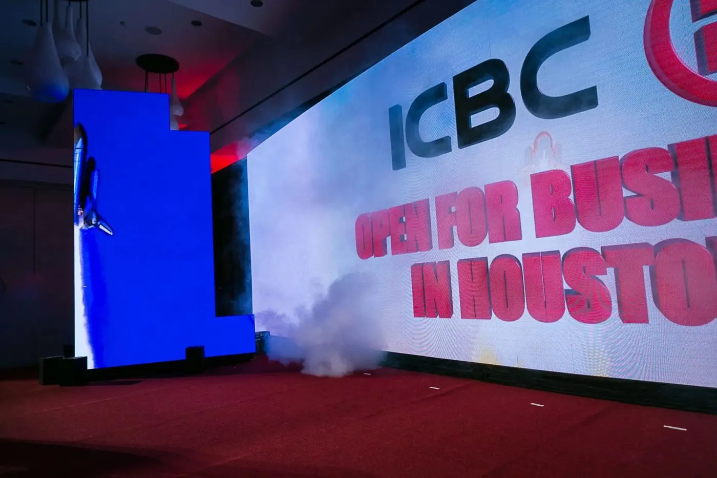 Grand opening stage with a bank brand backdrop and speaker