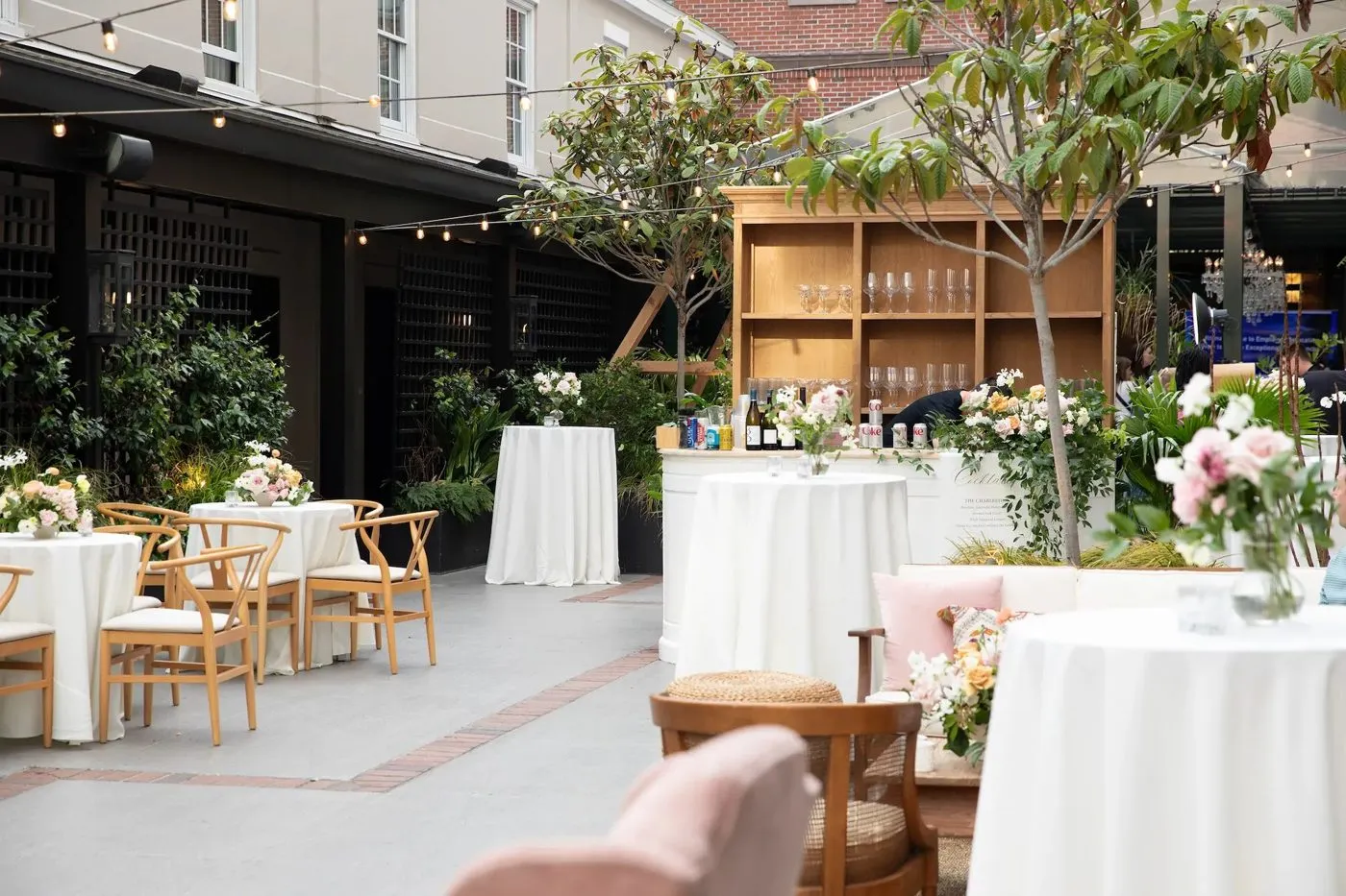 Patio reception with cocktail tables and floral arrangements