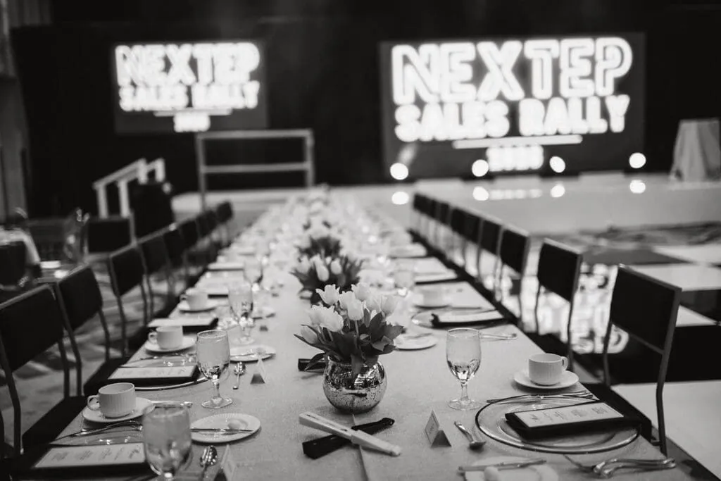 Long banquet tables set beneath a sales rally sign