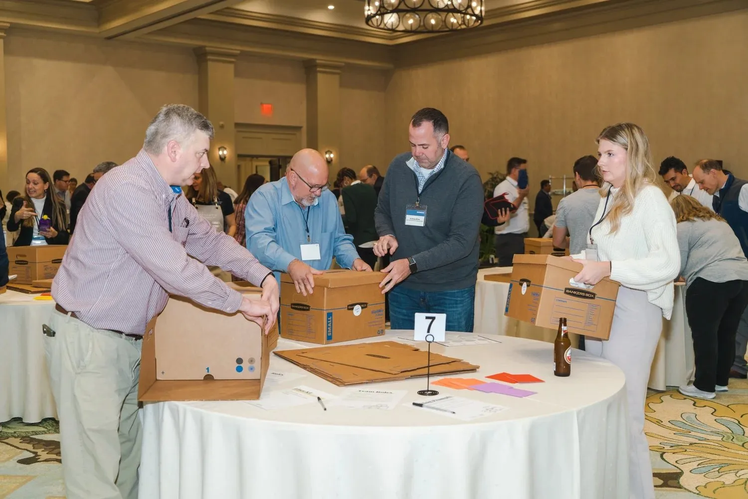 Corporate attendees assembling projects at a team service activity in a ballroom