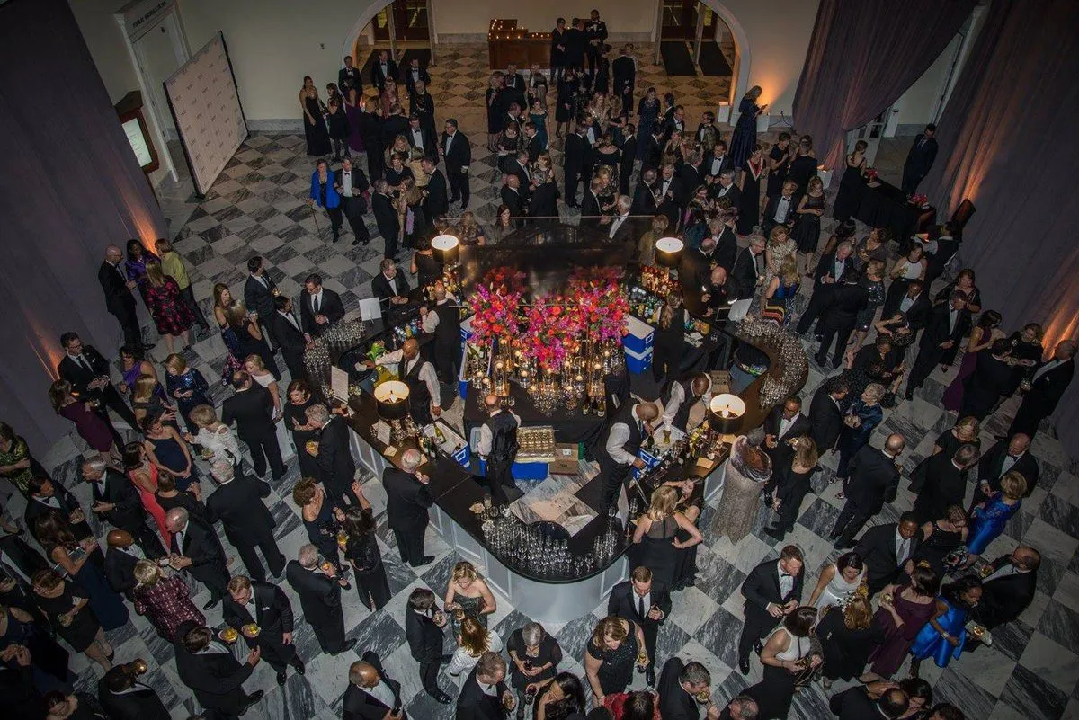 Aerial view of guests mingling around a floral centerpiece in a large hall
