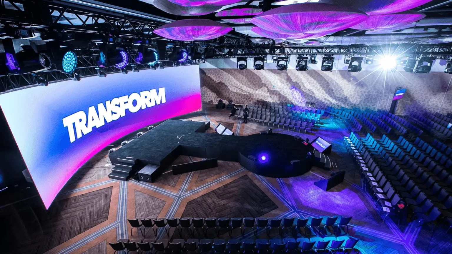 General session stage with a curved LED screen and audience seating