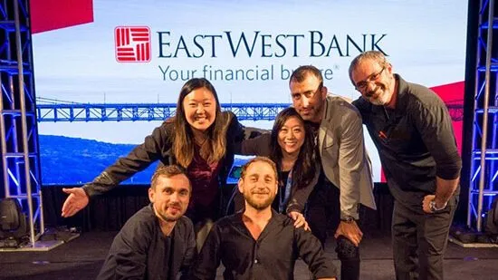 Group photo of attendees in front of a large branded screen