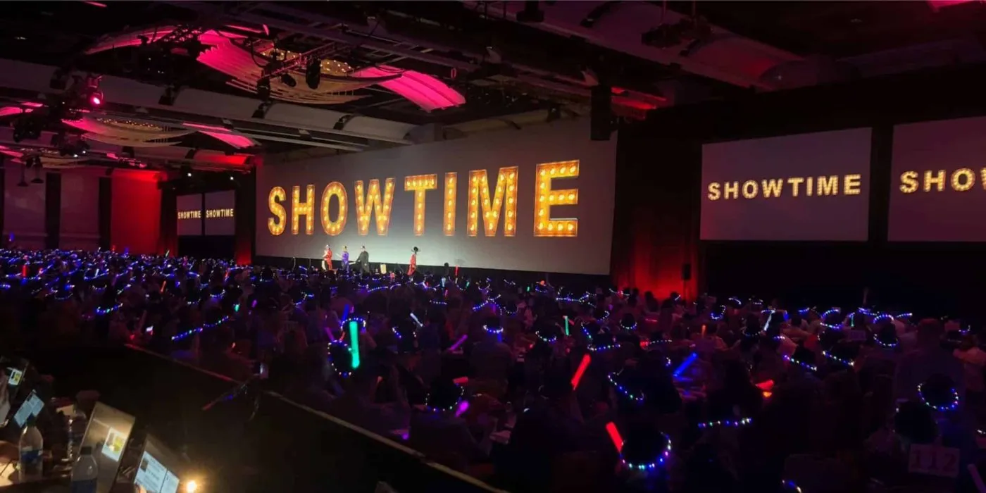 General session with large lit show title screens above an audience