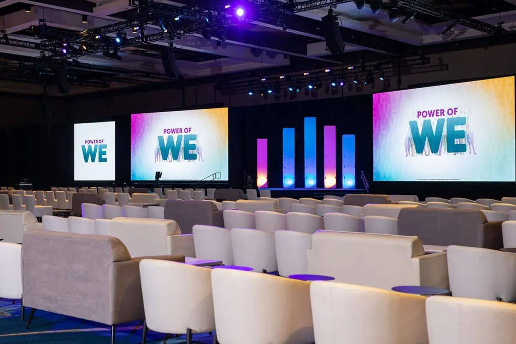 General session stage with large screens and lounge seating in a hotel ballroom