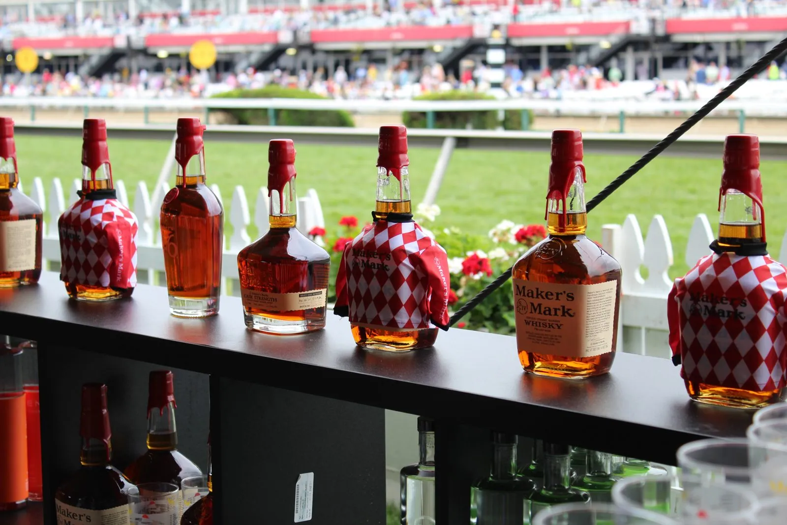Row of branded bottles on a bar at an outdoor sporting venue