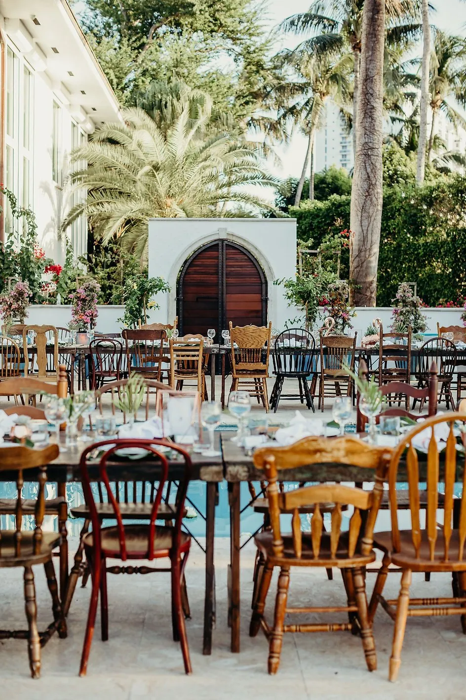 Long dinner tables set in a palm-lined courtyard for a corporate dinner in Miami Beach