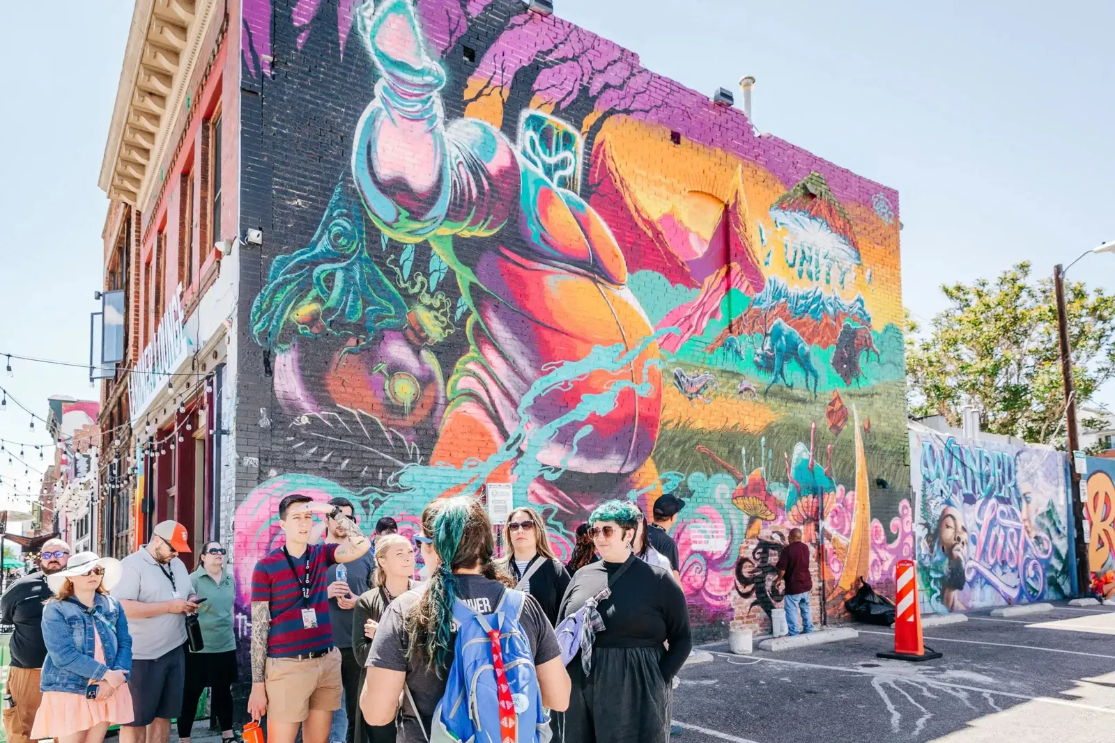Corporate group gathered in front of a large street mural during an Operation Altitude program