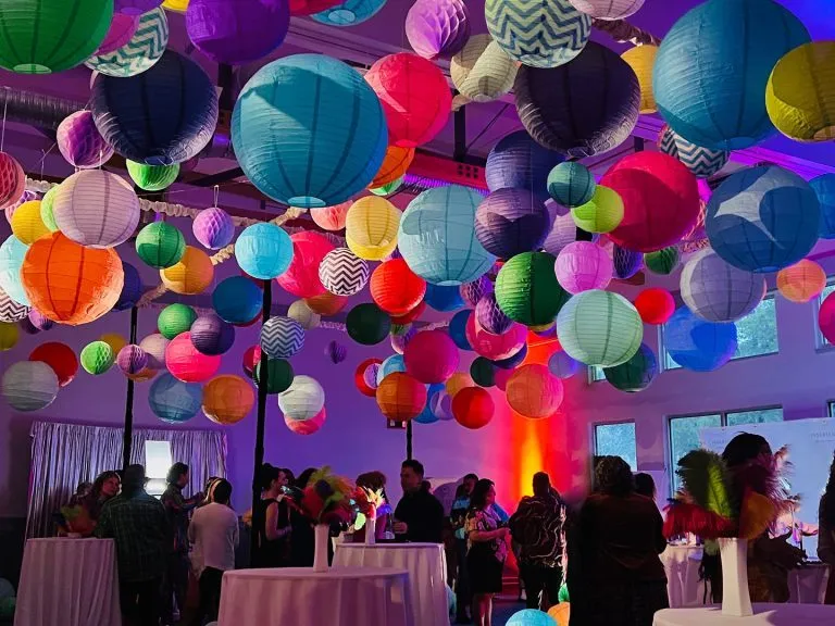 Colored paper lanterns hanging above tables at a corporate reception