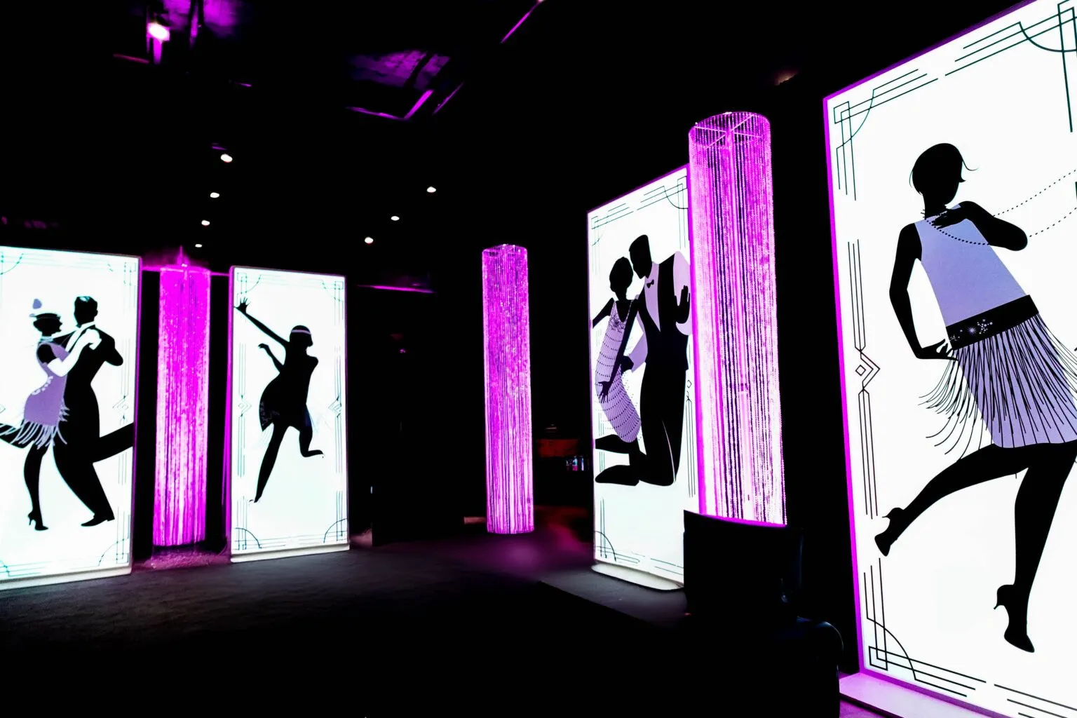 Stage set with lit panels showing dancer silhouettes at a corporate event