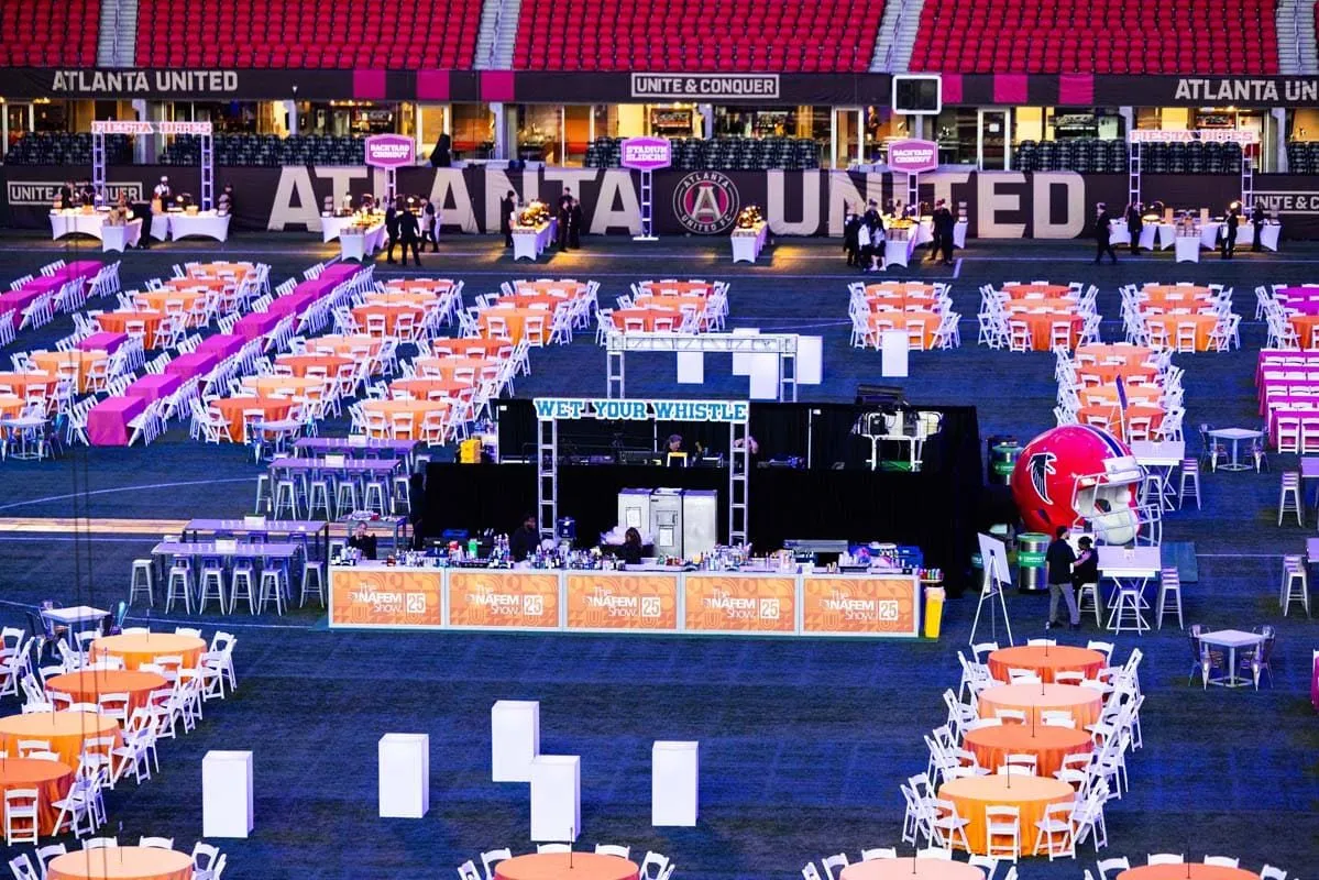 Stadium pitch covered with dinner tables for a large group function