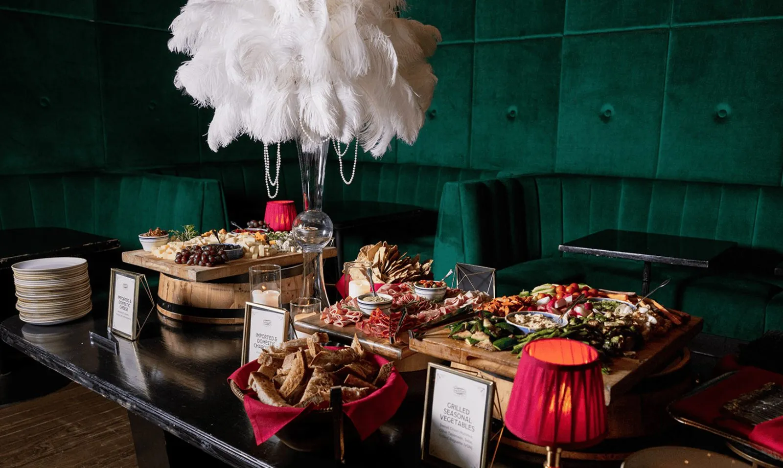 Grazing table with food displays and feather decor at an event reception