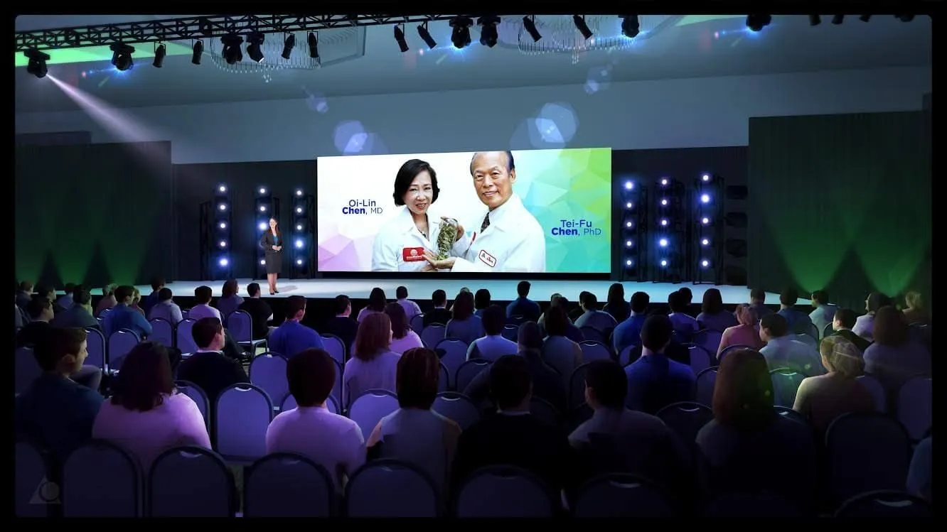 Corporate stage presentation with large LED screens and audience seating