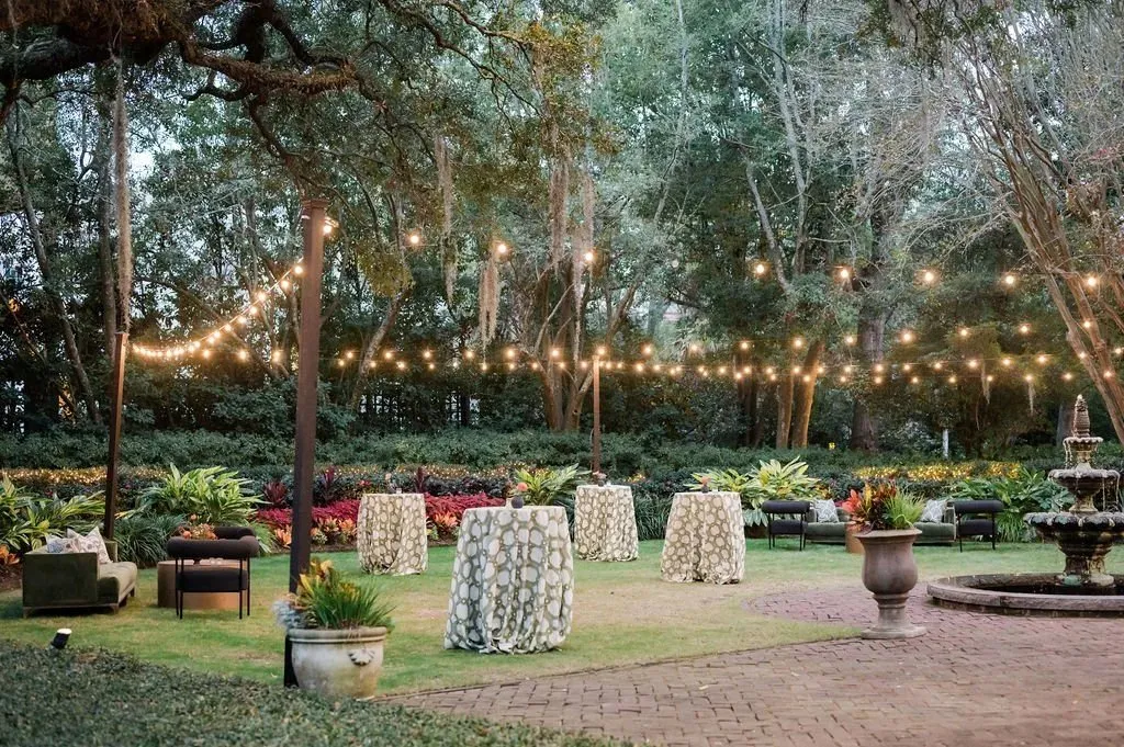 Evening garden reception with cocktail tables and string lights