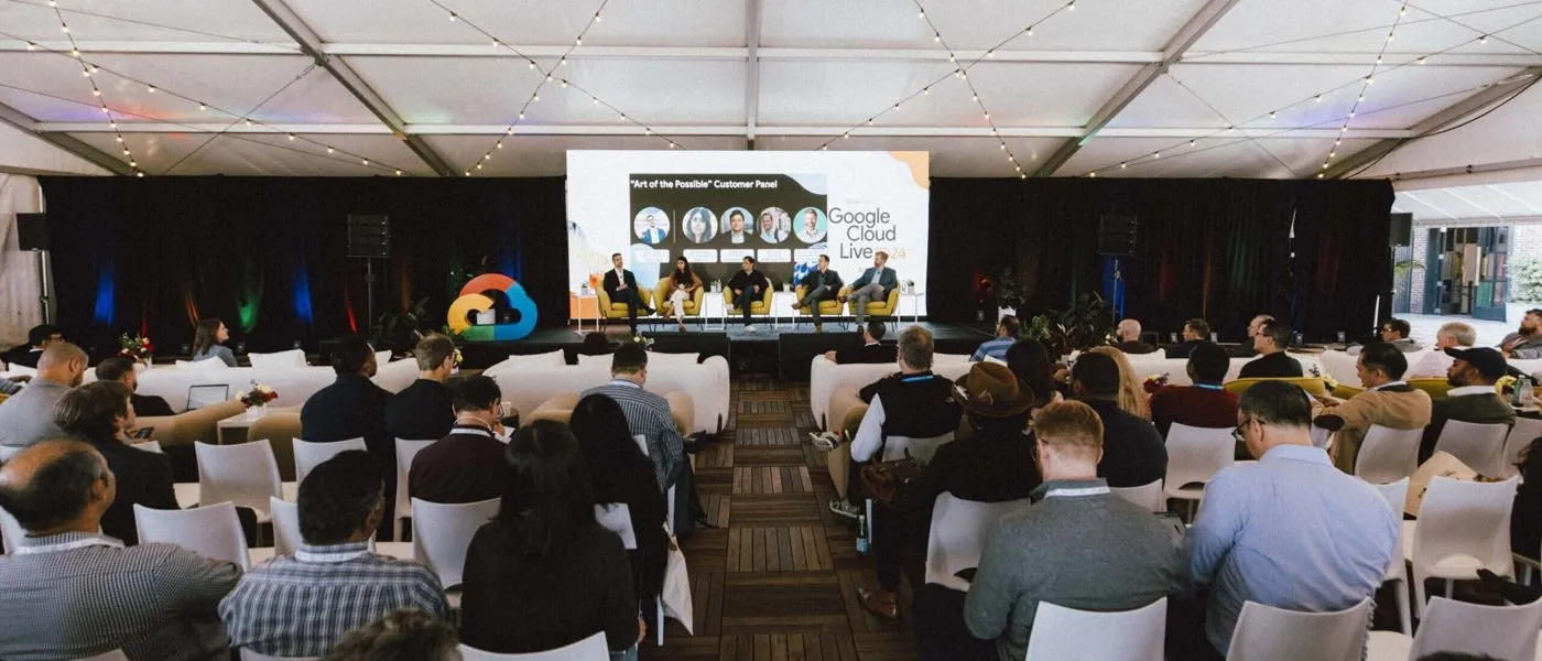 Attendees seated in a large tent for a live corporate event