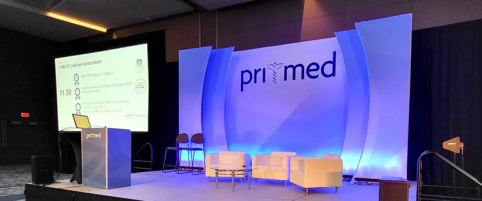 Pri-Med conference stage with lounge seating and screen