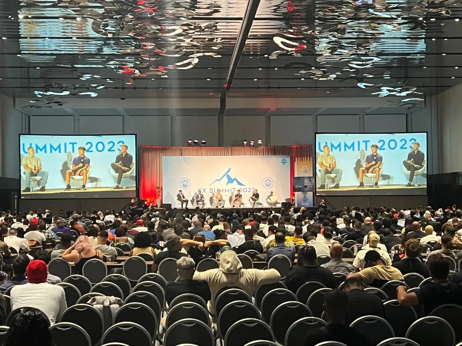 Summit general session with wide projection screens at the Miami Beach Convention Center