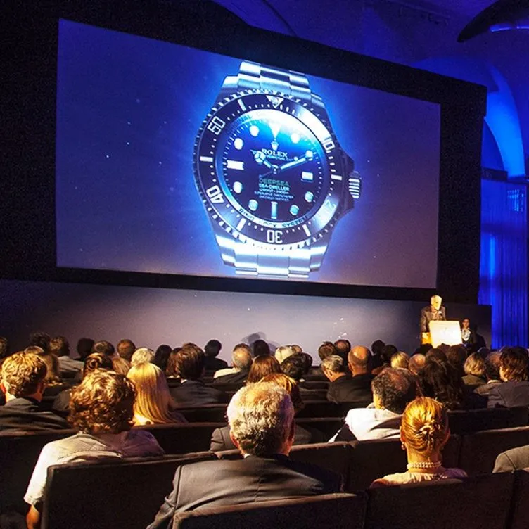 Audience watching a product launch presentation on a large screen