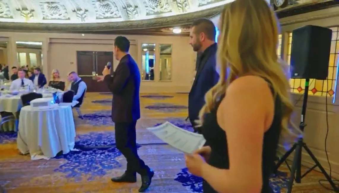 Speaker with a microphone addressing guests in an event space