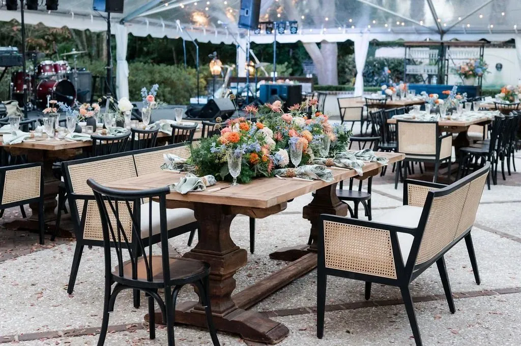 Rooftop dinner tables with wooden chairs and floral centerpieces
