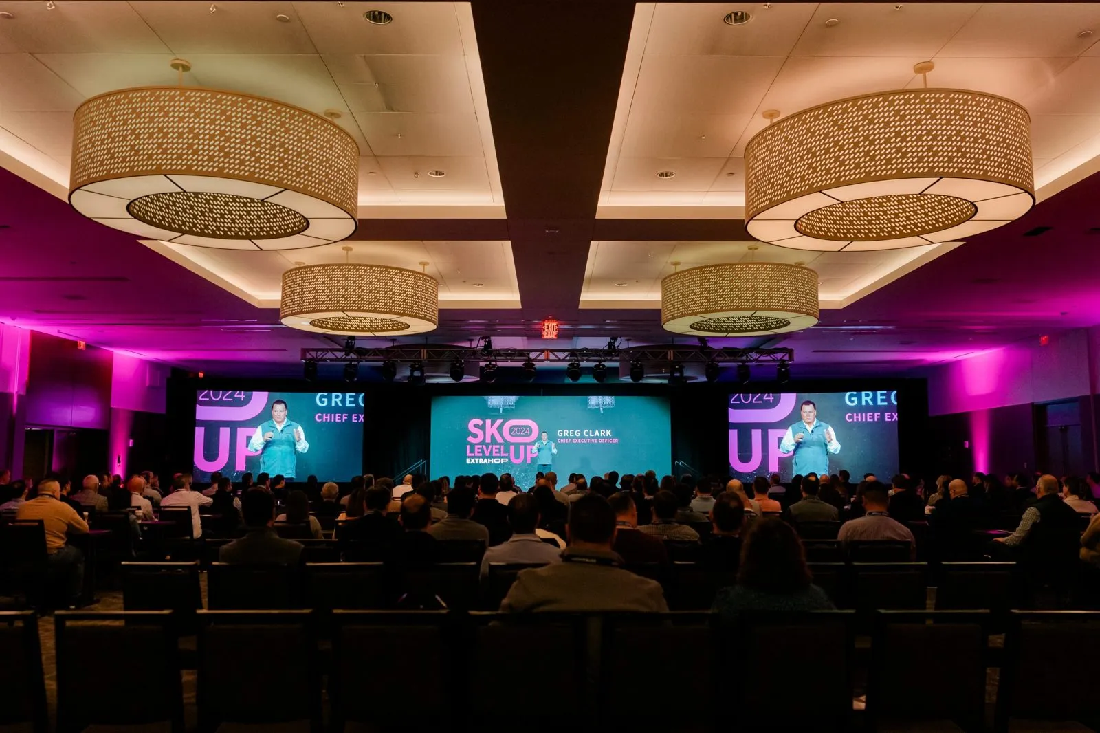 Ballroom with seated audience and stage screens at a company sales kickoff