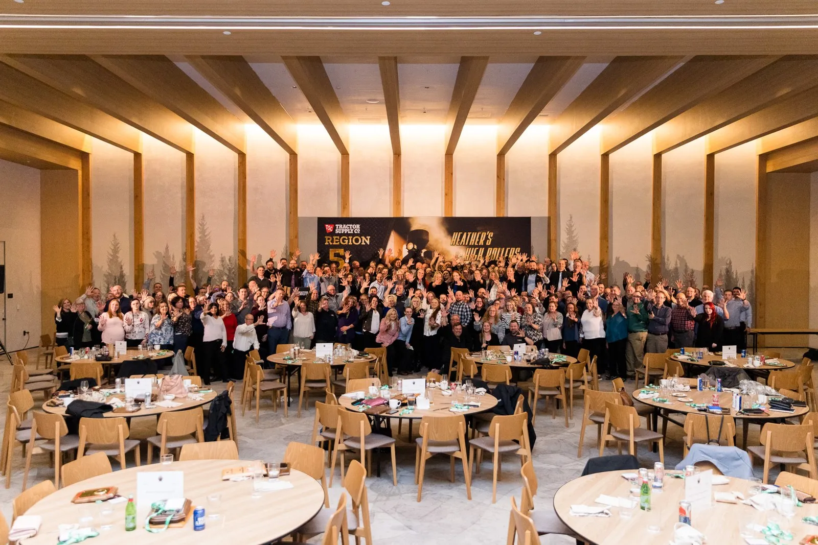 Group photo of regional dinner attendees in a banquet room with round tables