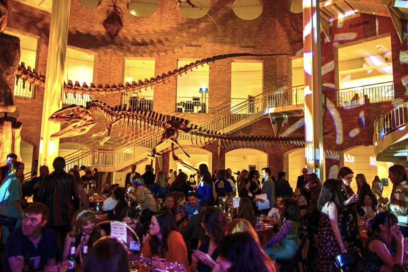 Packed event hall with a large audience and a stage under bright lighting