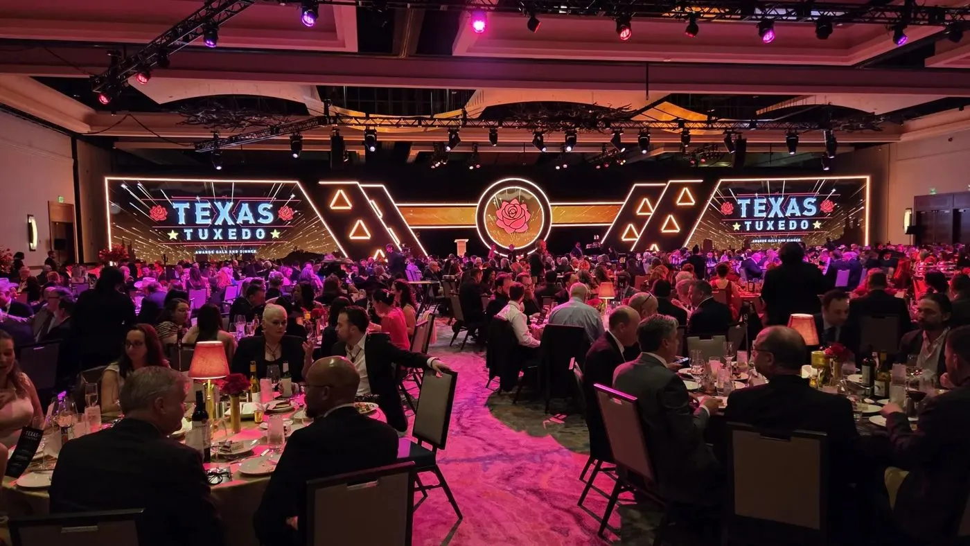 Ballroom dinner with a branded stage backdrop at a conference