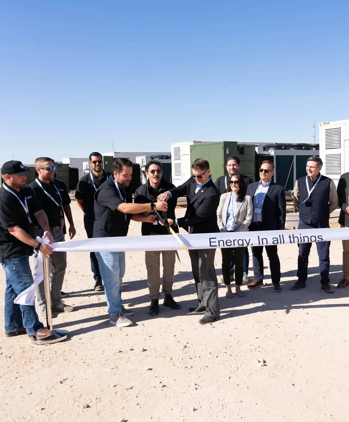 Group at an outdoor ribbon cutting for a corporate milestone