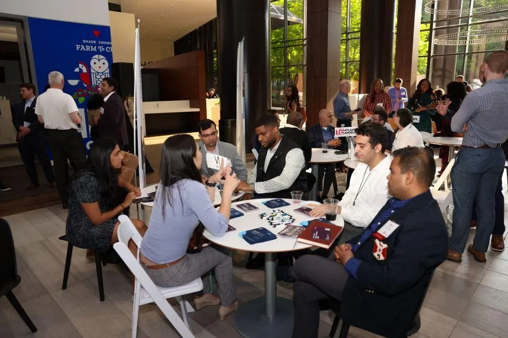 Attendees networking at tables during a conference break