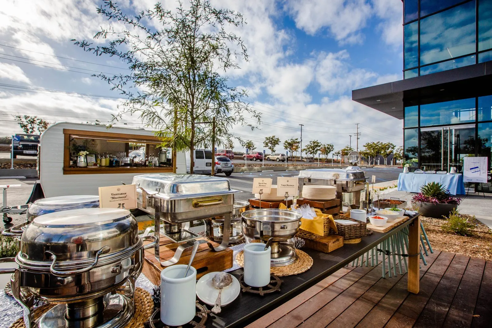 Outdoor buffet stations at a corporate event near a waterfront building