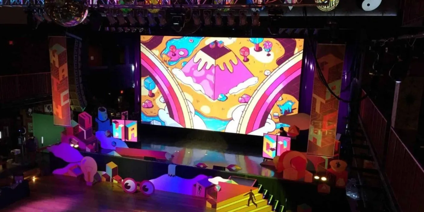 Colorful stage with a large LED screen and themed lounge set